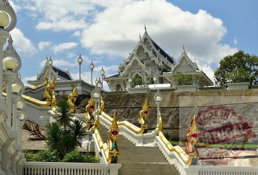 Wat Kaew Korawaram temple with naga staircase leading to ubosot in Krabi Town, Thailand | Golden naga staircase leading to the white ubosot of Wat Kaew Korawaram temple in Krabi, Thailand, with cloudy sky - Realized with Pictrs.com