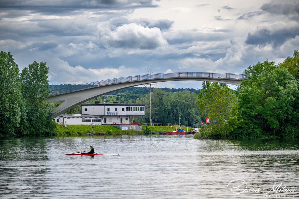 Die Dykerhoff-Brücke | Die Dyckerhoff-Brücke ist eine Fußgängerbrücke in Wiesbaden, die mit einem 96,40 m weiten Bogen die Hafenausfahrt des Schiersteiner Hafens überspannt. Das Bauwerk wurde 1967 errichtet und ist eine Spannbetonkonstruktion, die im Freivorbau hergestellt wurde. Dabei wurde erstmals in Deutschland zur Reduzierung der Lasten größtenteils Leichtbeton verwendet.