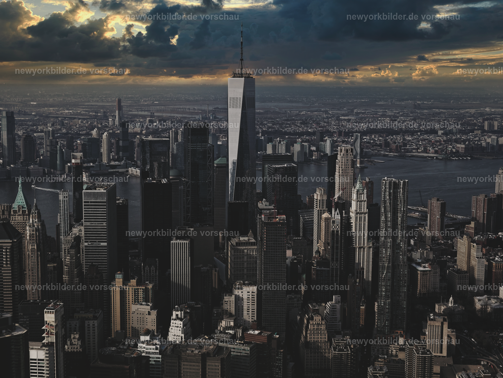Dramatische Stimmung – One World Trade Center & Downtown aus der Luft | Ein Helikopterflug über Downtown Manhattan eröffnet eine Perspektive, die pure Faszination ausstrahlt. Das majestätische One World Trade Center ragt in den Himmel, während sich im Hintergrund der Hudson River erstreckt. Die Sonne verabschiedet sich hinter dunklen Wolken, die der Szene eine dramatische und zugleich magische Stimmung verleihen. Dieses Foto zeigt die Kraft der Architektur und die Schönheit der Natur in perfekter Harmonie – ein Moment, der die Energie von New York in ihrer intensivsten Form einfängt. Die Kombination aus Licht, Schatten und der imposanten Skyline macht dieses Motiv zu einem visuellen Erlebnis, das Abenteuer und Emotion vereint.