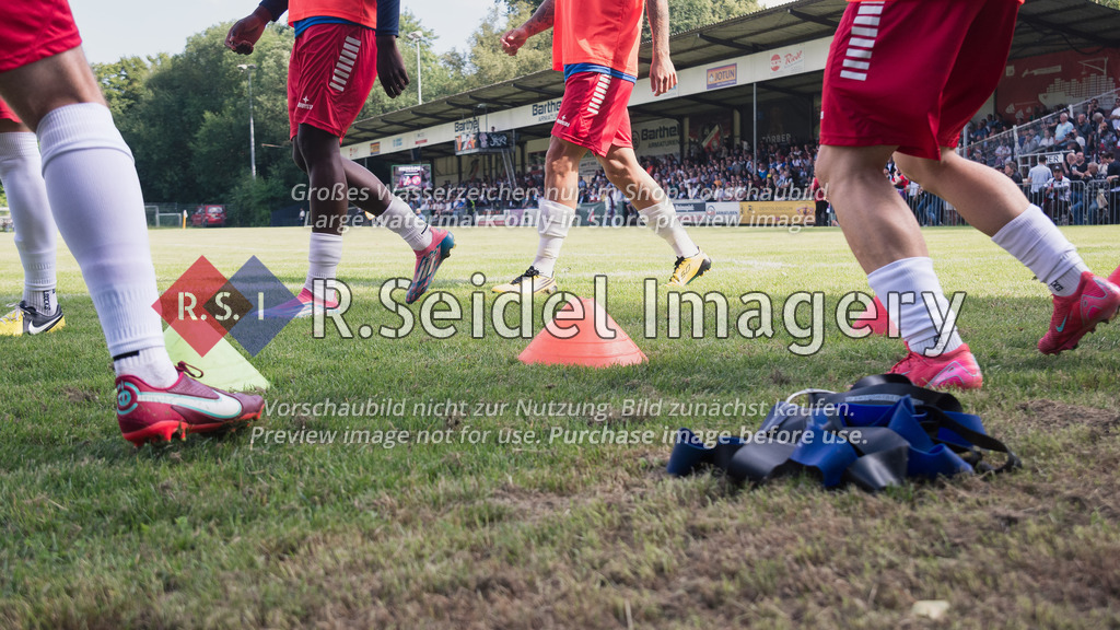 RS-1-126410 | Spieler wärmen sich an den Trainingshütchen neben dem Feld auf