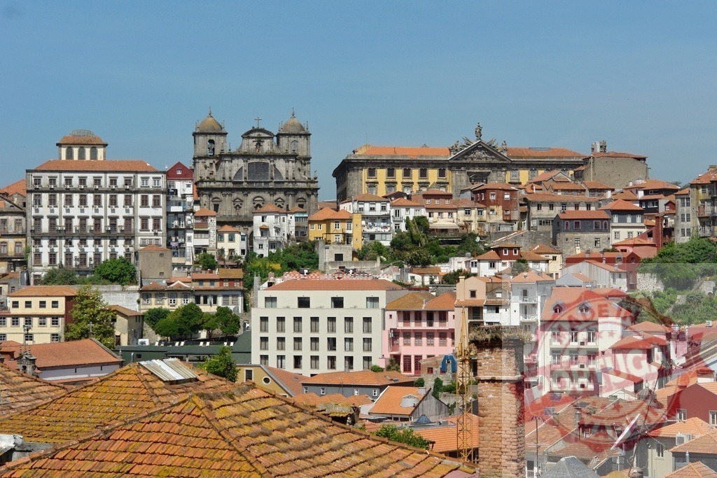 Porto city view with historic buildings and rooftops | Porto city skyline showcasing historic architecture, a church, colorful houses - Realized with Pictrs.com
