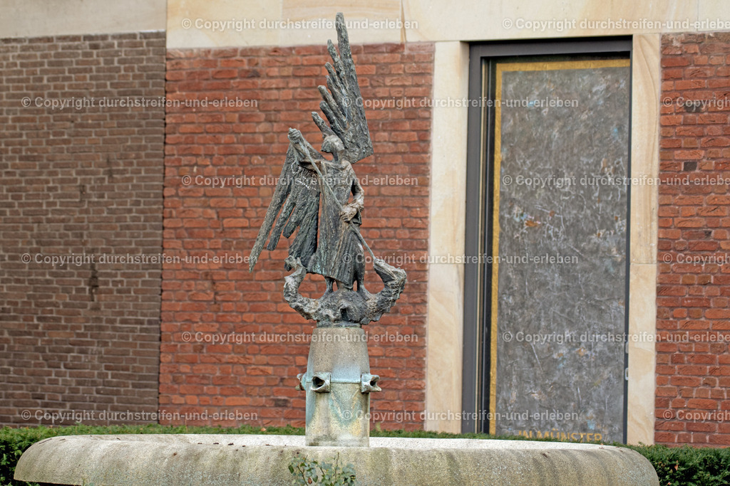 St. Michaelsbrunnen in Münster | Der Michaelisbrunnen zeigt den Heiligen Michael auf einem Drachen. Er steht am Rande des Domplatzes. - Realisiert mit Pictrs.com