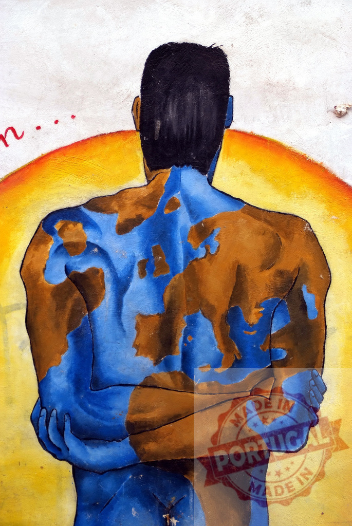 Man with earth painted on his back embracing himself in front of rising sun | Mural painting of a man with earth map painted on his back embracing himself in front of a rising sun - Realisiert mit Pictrs.com