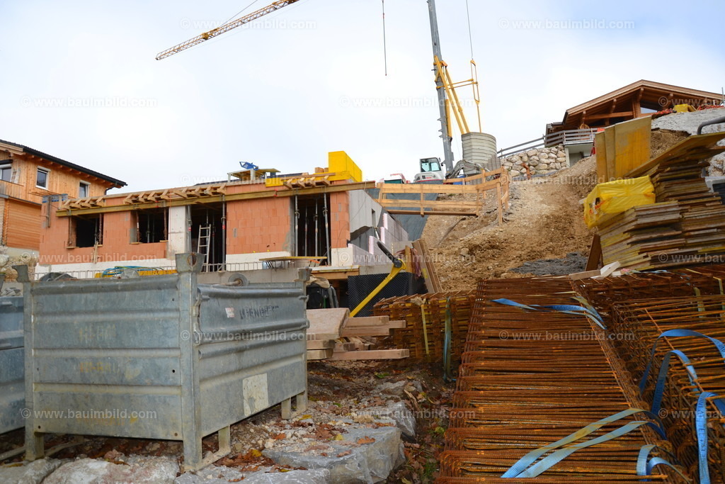 Baustelle am Hang mit Baukran | Lagerplatz mit Baustahl und Schalungsmaterial 