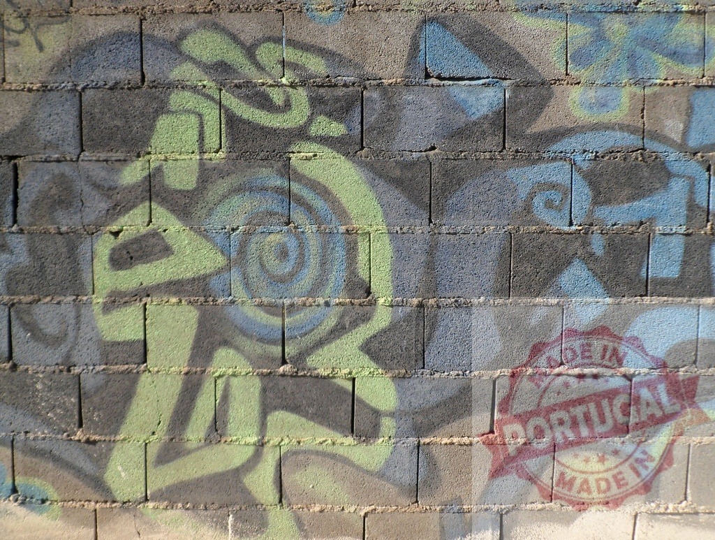 Abstract graffiti painting covering urban concrete wall | Abstract graffiti art spray painted in blue and green on a textured concrete block wall - Realisiert mit Pictrs.com