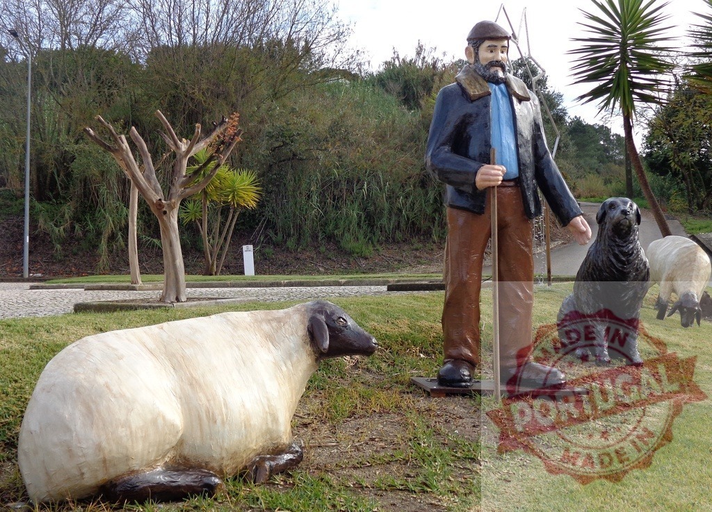 Shepherd statue holding stick standing with sheepdog and sheep | Shepherd statue holding stick standing with sheepdog and sheep in a park - Realized with Pictrs.com