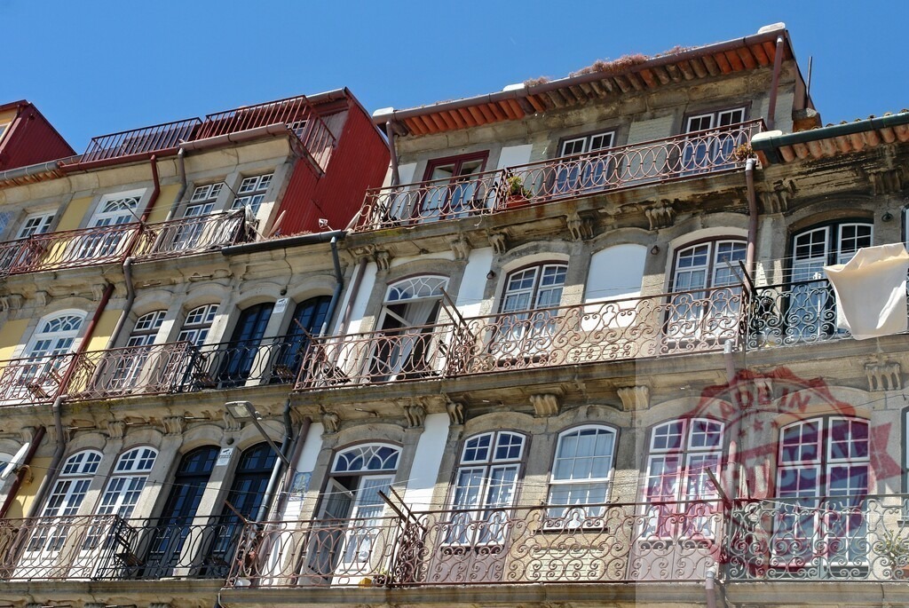 Porto city old building facade with balconies and windows. Porto - Portugal | Porto old building facade showing multiple balconies and windows under blue sky - Realized with Pictrs.com