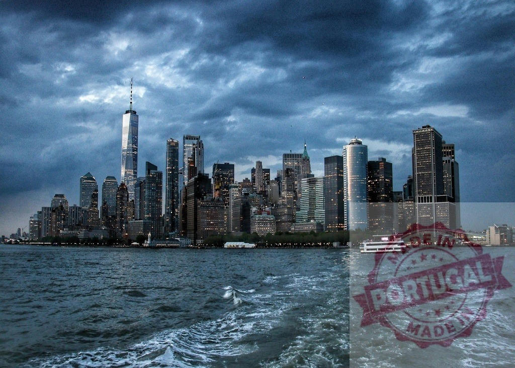 New York City skyline and stormy evening clouds over One World Trade Center | Lower Manhattan skyline rising from the water under dramatic storm clouds at dusk - Realized with Pictrs.com