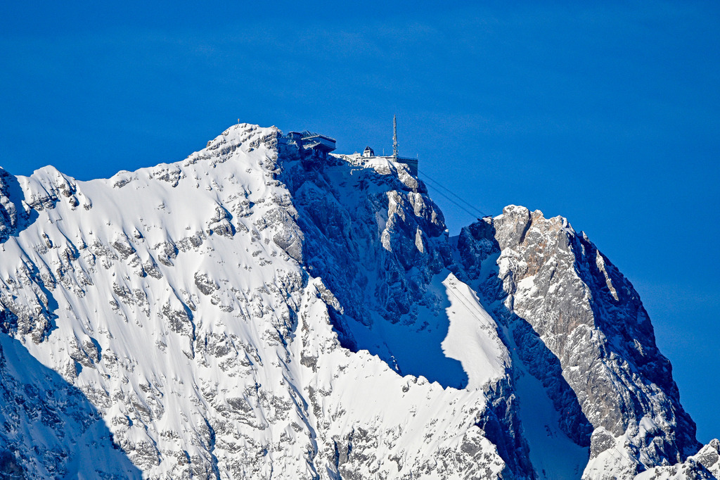 Dem Himmel so nah: Die Zugspitze | Spüre die Freiheit des Gipfels! Dieses beeindruckende Motiv fängt Deutschlands höchsten Punkt, die Zugspitze, in ihrer ganzen winterlichen Pracht ein. Die schneebedeckten, schroffen Felswände und die markante Bergstation vor dem tiefblauen Himmel bringen die unbändige Kraft der Alpen direkt in Deine Räume. Hol Dir dieses Gefühl von Weite, Abenteuer und Ruhe als edlen Galerie-Print nach Hause. Perfekt als Leinwand, Acrylglas oder Poster für Dein Wohnzimmer! - Realisiert mit Pictrs.com