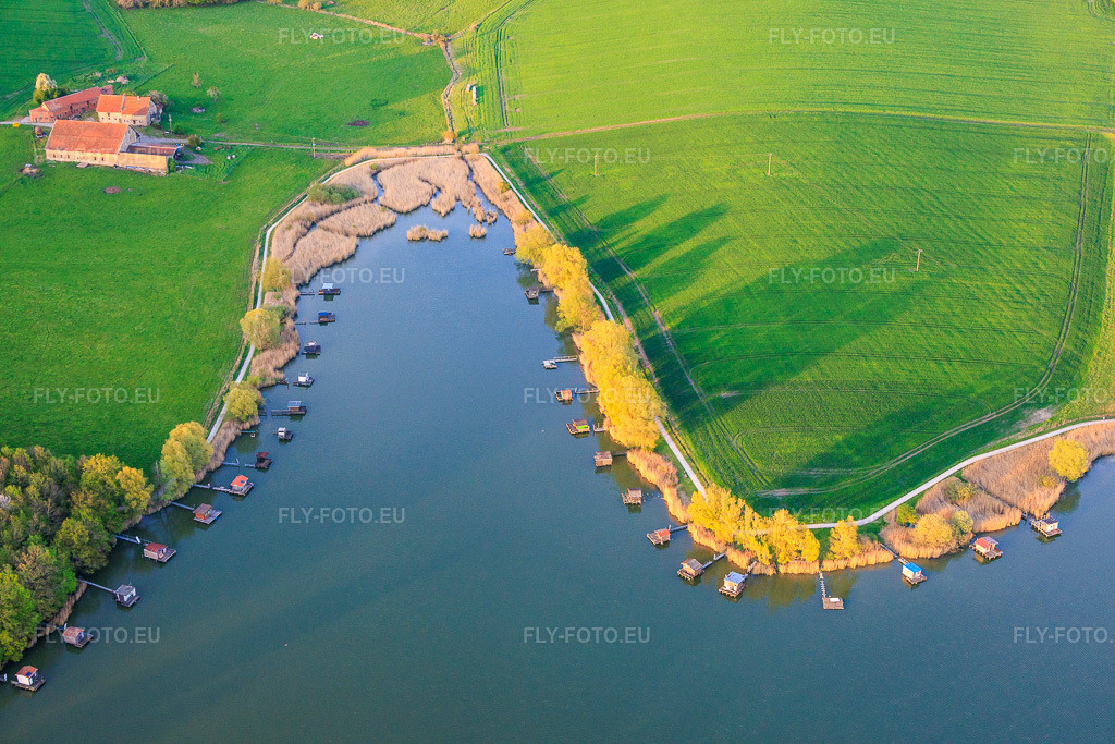 Vue aérienne: Des promenades en bois bordées de cabanes de pêcheurs longent les rives de l'étang du Welschhof. à Puttelange-aux-Lacs dans le département Moselle, France.Photo: IMG_154402.jpg prise le 17/04/2026 par Werner Riehm/FLY-FOTO.euRésolution de l'original: 6000 x 4000 px