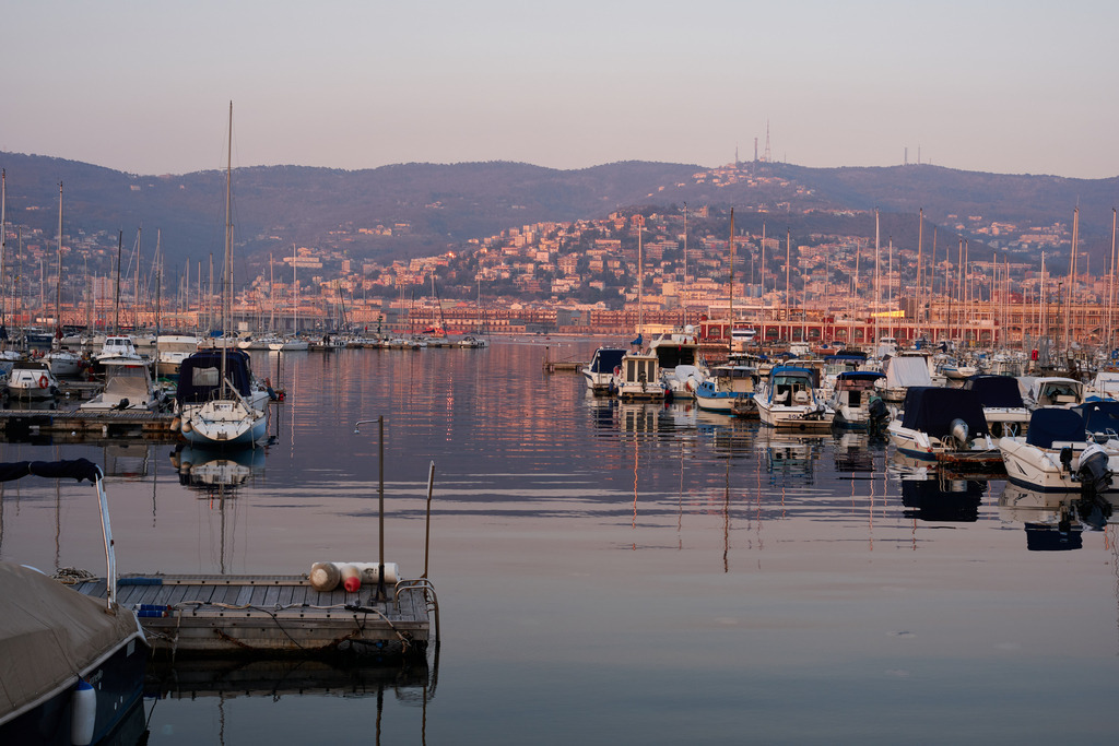 Blick auf den Hafenund das Ufer | Triest, Austria - March 10, 2022: Blick auf den Hafen und das Ufer im Abendlicht. - Realisiert mit Pictrs.com