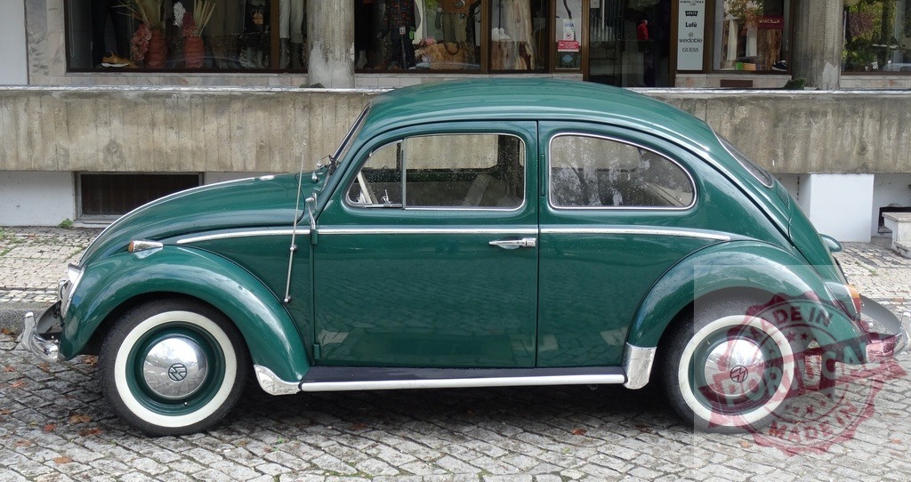 Volkswagen Beetle classic car parked on cobblestone street | Green Volkswagen Beetle with whitewall tires parked outdoors, displaying timeless automotive design - Realized with Pictrs.com