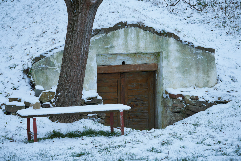 Eingang zum verschneiten Weinkeller | Seebarn, Austria - December 28, 2014: Kellergasse-Kellerweg; Eingang zum verschneiten Weinkeller mit Holzbank davor. - Realisiert mit Pictrs.com