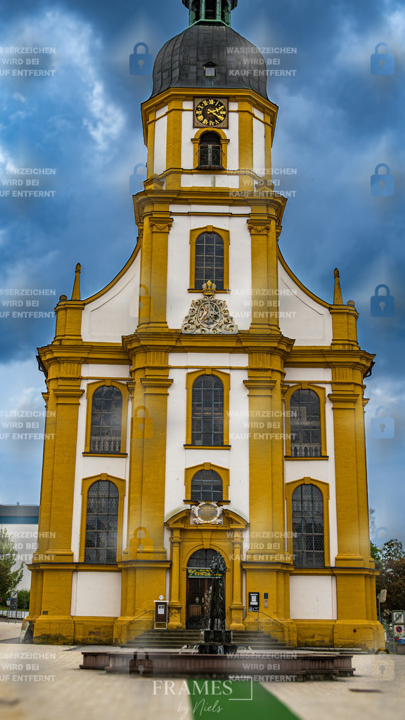 Kreuzkirche Suhl | Das Foto zeigt die Kreuzkirche in Suhl, deren sandfarbene bis gelbliche Säulen besonders markant vor dem hellen Himmel hervorstechen. Die Aufnahme betont den architektonischen Kontrast zwischen den warmen Farbtönen des Kirchenbaus und dem klaren Hintergrund, wodurch die vertikale Struktur und die feinen Details der Säulen deutlich zur Geltung kommen. Die Perspektive unterstreicht die historische Bedeutung des Bauwerks und verleiht der Szene eine ruhige, zugleich eindrucksvolle Atmosphäre. Das Bild fängt sowohl die charakteristische Farbgebung der Kirche als auch ihre prägnante Silhouette ein. - Realisiert mit Pictrs.com