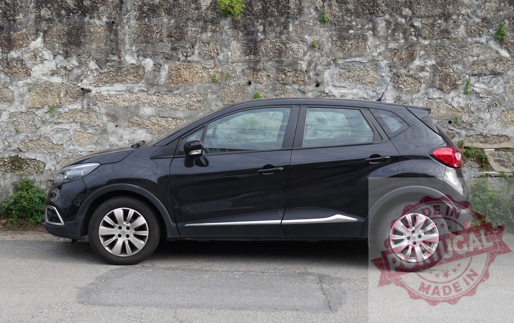 Black Renault Captur parked on street near stone wall | Black Renault Captur compact SUV parked in profile on an asphalt road next to a rustic stone wall - Realisiert mit Pictrs.com