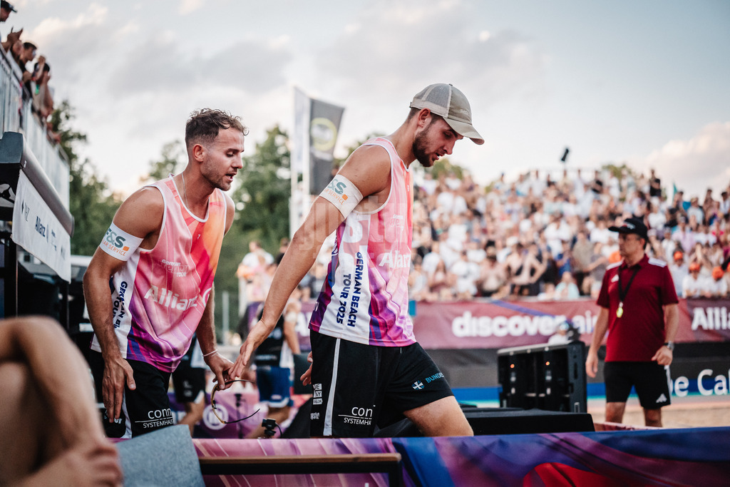 Beachvolleyball | Männer | Allianz German Beach Tour 2025 | Tourstop München | 05.07.2025 | v.l. Jonas Sagstetter und Benedikt Sagstetter laufen nach der Auszeit in das Stadion