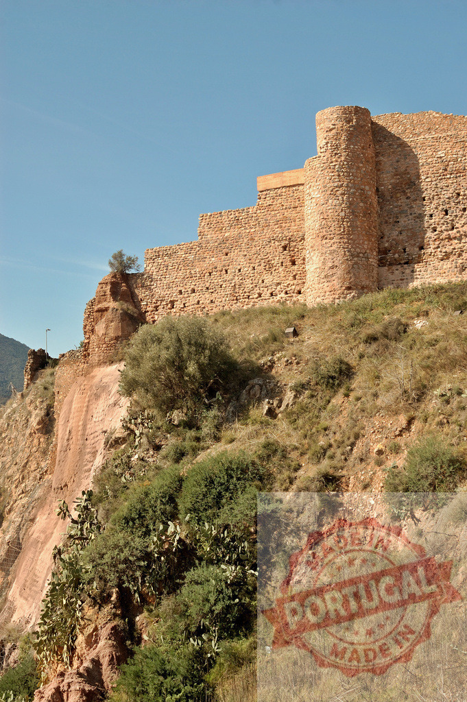 Ancient castle ruins on a rocky hillside under clear sky | Ancient castle ruins stand on a rocky slope, showing historical architecture and stone walls - Realisiert mit Pictrs.com