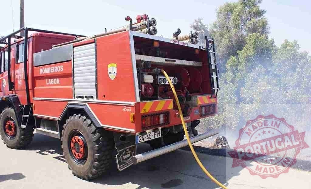Lagoa Bombeiros fire engine fighting wildfire | Red Bombeiros fire truck with hose extinguishing a roadside wildfire, creating smoke - Realisiert mit Pictrs.com