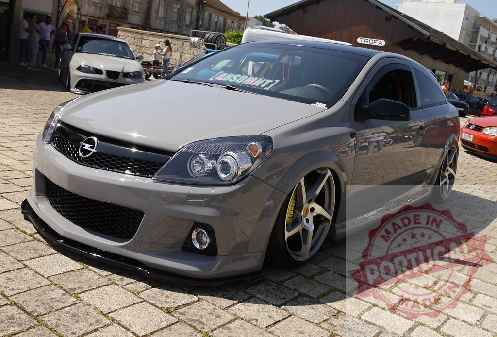 Opel Astra GTC custom gray car stanced at show | Custom gray Opel Astra GTC car with modifications sitting low at a car show - Realized with Pictrs.com