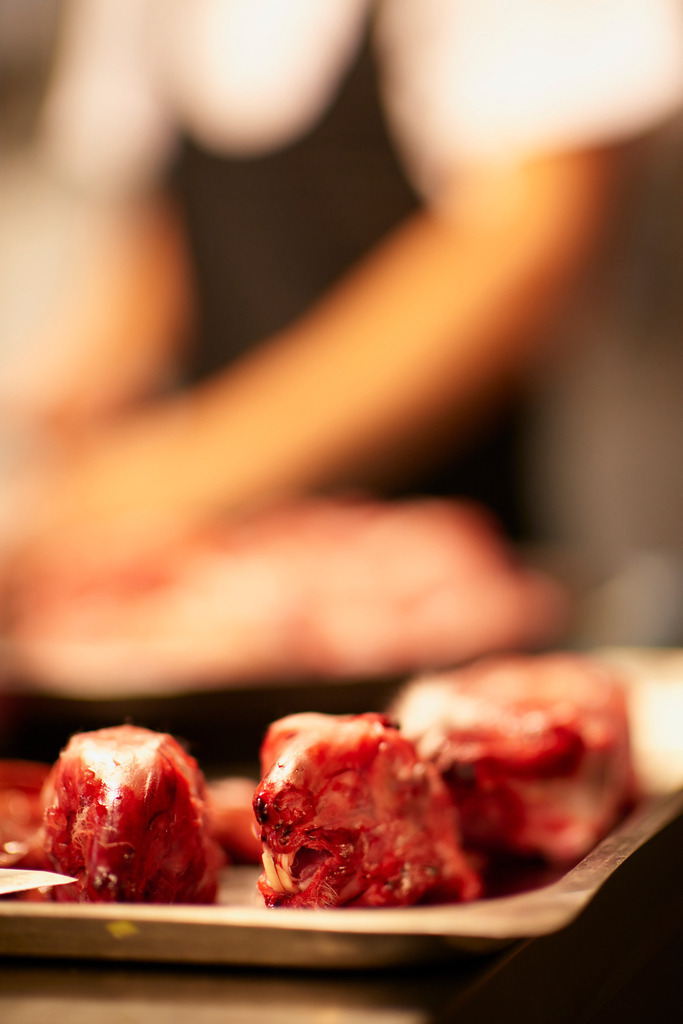 Enthäutete Hasenköpfe auf einer Platte, im Hintergrund ein Koch | Siena, Italien - September 01, 2016: Restaurant Trattoria, Tre Cristi; Enthäutete Hasenköpfe auf einer Platte, im Hintergrund ein Koch.  - Realisiert mit Pictrs.com