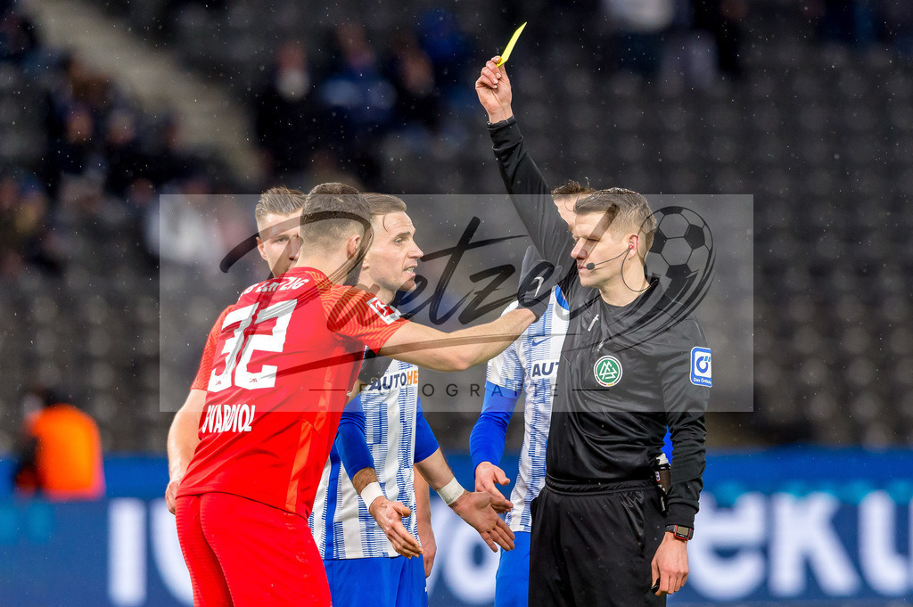 BSCRBL20220220_055 | Fussball, Herren: Schiedsrichter Patrick Ittrich zeigt Josko Gvardiol (RB Leipzig) die gelbe Karte bei dem Spiel der 1. Bundesliga zwischen Hertha BSC und RB Leipzig im Olypiastadion am 20.02.2022 in Berlin, Deutschland.DFB / DFL REGULATIONS PROHIBIT ANY USE OF PHOTOGRAPHS AS IMAGE SEQUENCES AND/OR QUASI-VIDEO. - Realisiert mit Pictrs.com