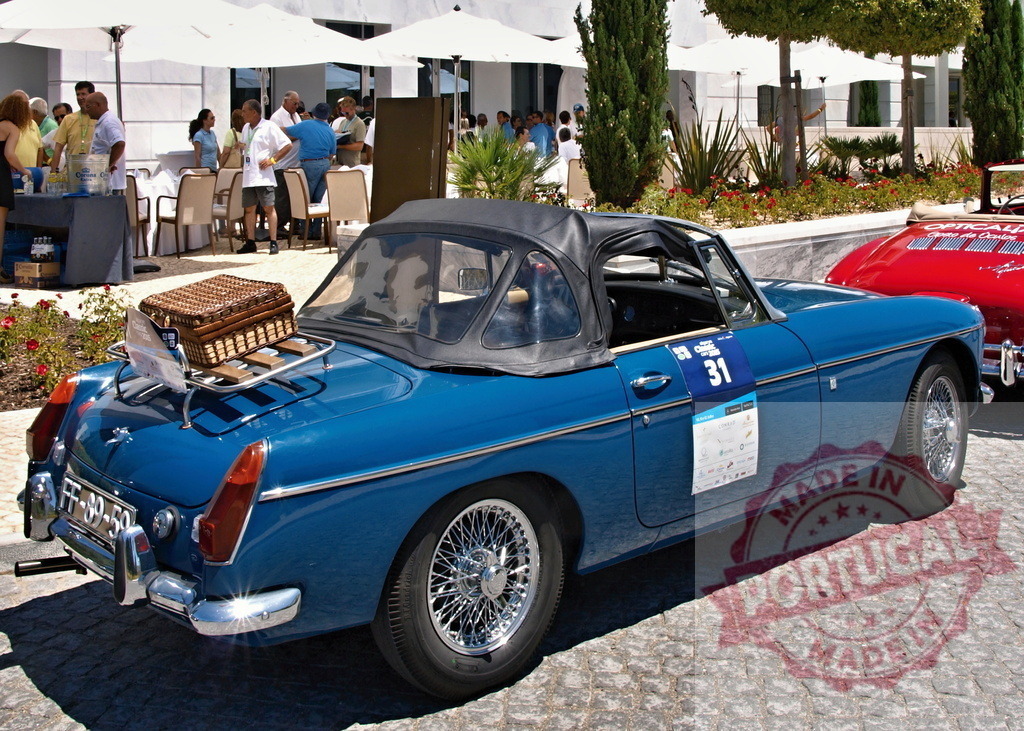 Shiny blue MG parked near a luxury hotel during a classic car rally | Classic blue MG convertible parked near a luxury hotel during a classic car rally, with a picnic basket on the luggage rack - Realisiert mit Pictrs.com