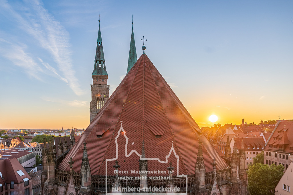 Monatsbild des Kalender 2026 für den Monat April | Blick auf die Sebalduskirche in Nürnberg, Bayern, Deutschland, bei Sonnenuntergang. Die Aufnahme zeigt das steile Hauptdach mit gotischen Strebepfeilern und die beiden Kirchtürme im Hintergrund. Die Sonne geht hinter den Dächern der Altstadt unter, während der Himmel in warmen Farben leuchtet. - Realisiert mit Pictrs.com