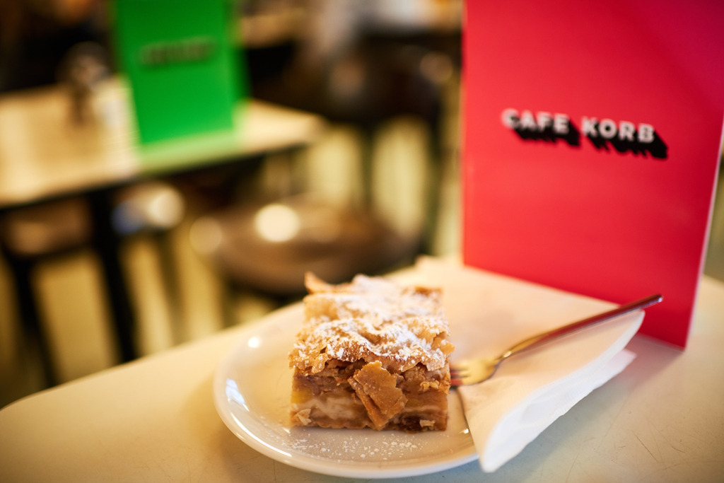 Cafe Korb | Wien, Austria - January 28, 2019: Cafe Korb; ein Apfelstrudel und eine rote Speisekarte stehen auf dem Tisch. - Realisiert mit Pictrs.com