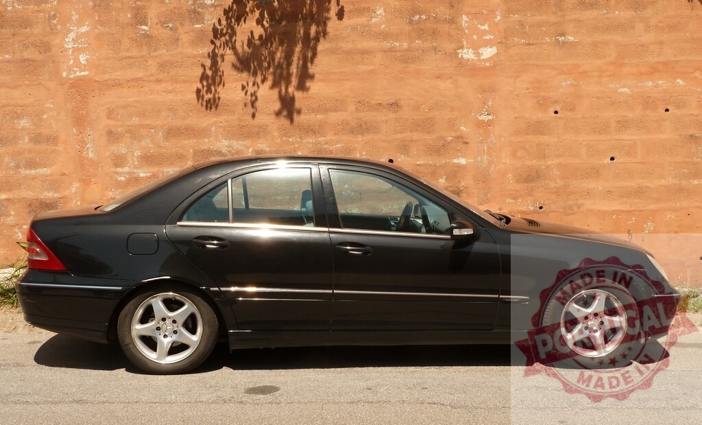 Mercedes-Benz C-Class luxury sedan parked by wall | Black Mercedes-Benz C-Class sedan parked on a street next to an old clay wall - Realized with Pictrs.com