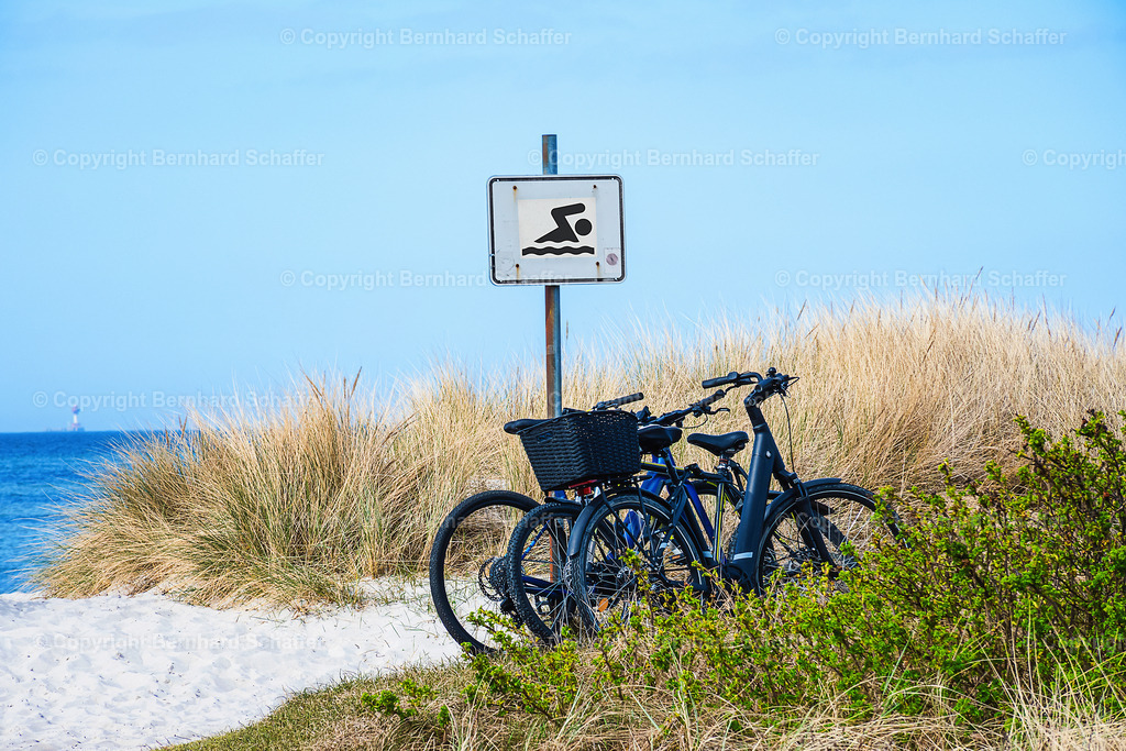 Fahrräder am Badestrand | In den Dünen an einem Strand der Ostsee sind drei Fahrräder an einem Schild Badestrand angelehnt. - Realisiert mit Pictrs.com