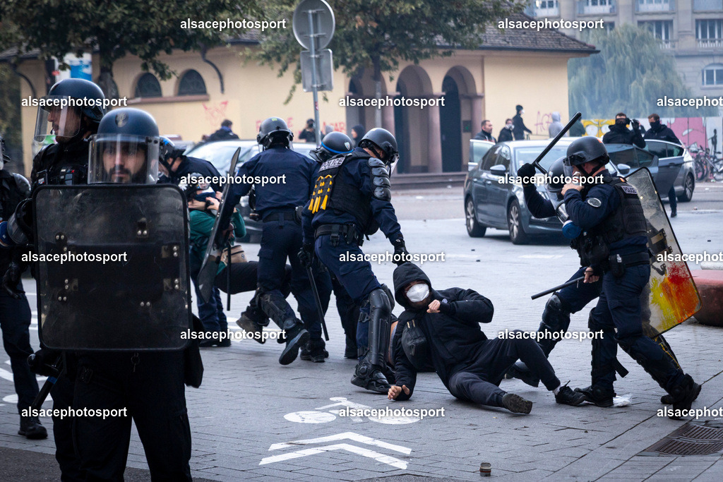 9L6A7051 | Strasbourg, France, 24 octobre 2026. Des manifestants affrontent les forces de l’ordre lors d’une mobilisation dans le centre-ville de Strasbourg. Des policiers interviennent pour disperser des groupes de manifestants, tandis que des gaz lacrymogènes sont utilisés. Des affrontements, des jets de projectiles et des dégradations sont observés dans plusieurs rues. Des barricades et des véhicules en feu témoignent de la tension qui règne en marge de la mobilisation. - Realisiert mit Pictrs.com
