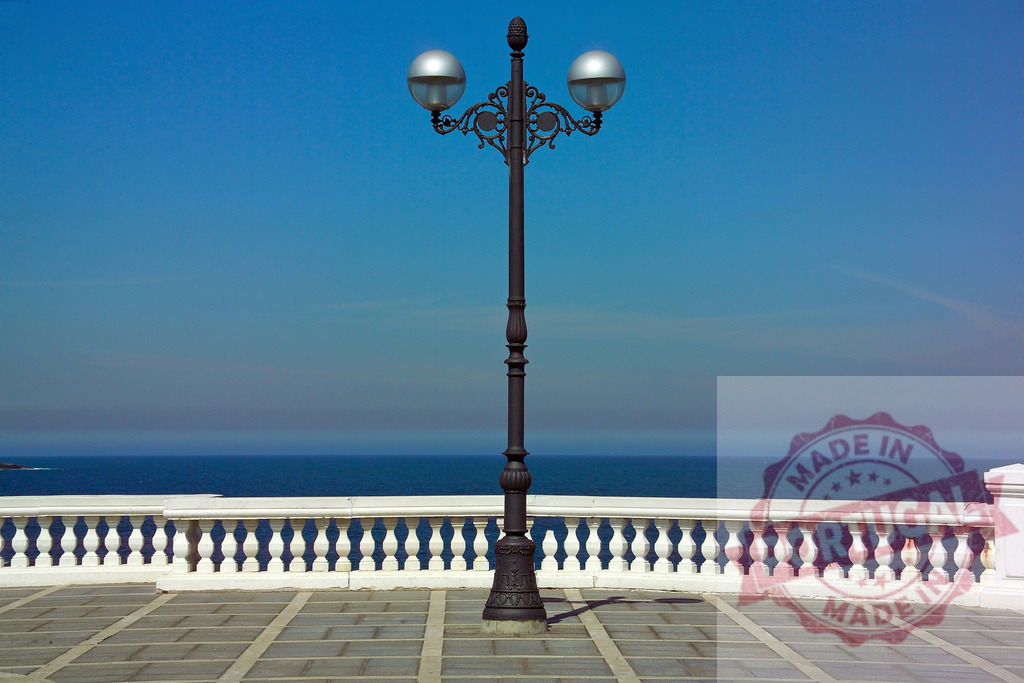 Ornate street lamp against blue sky and ocean view. Spain - Cantabria | Ornate street lamp standing on a promenade with balustrade overlooking the ocean under a clear blue sky - Realisiert mit Pictrs.com