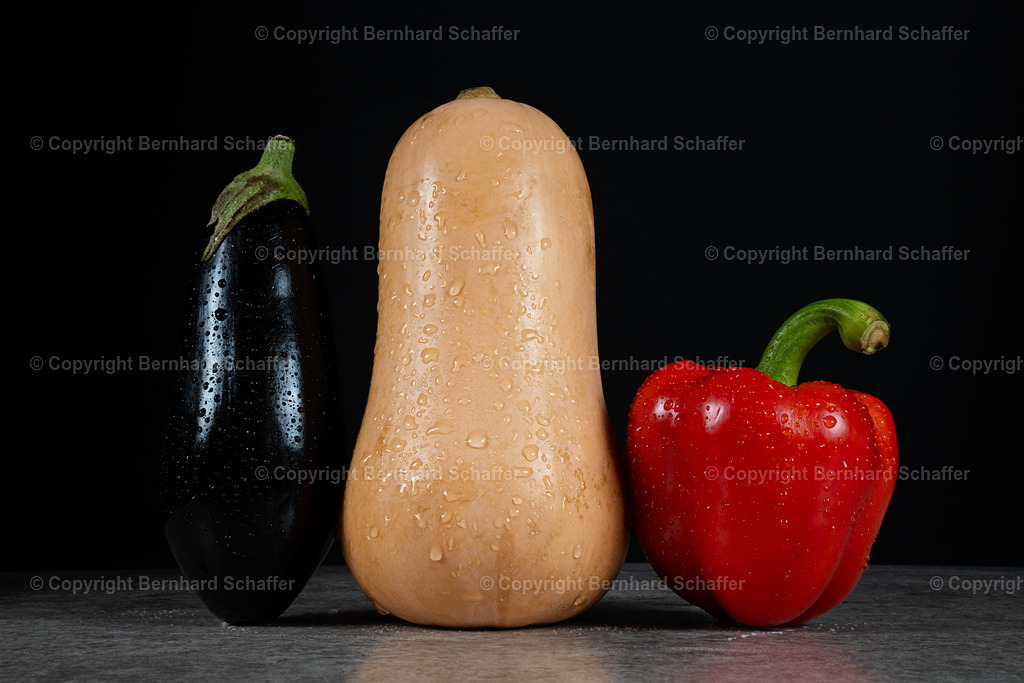 Avocado Kürbis Paprika | Drei frische Gemüsesorten – Aubergine, Kürbis und Paprika – stehen nebeneinander vor schwarzem Hintergrund. - Realisiert mit Pictrs.com