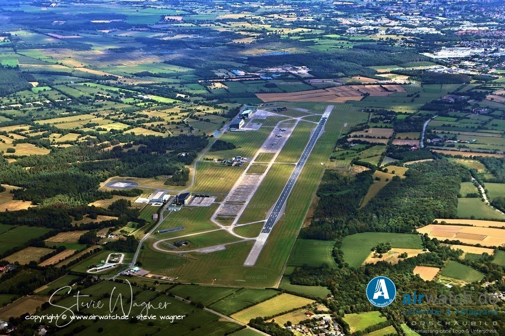 Luftbild Fliegerhorst Hohn - Die erste Bauphase war 1940 abgeschlossen, wobei die Hauptstartbahn in Ost-West-Richtung fertiggestellt wurde | Die erste Bauphase war 1940 abgeschlossen, wobei die Hauptstartbahn in Ost-West-Richtung fertiggestellt wurde, während eine zweite Bahn im Bau und eine dritte in Planung waren. Der weitere Ausbau erfolgte vor allem durch sowjetische Kriegsgefangene, doch bis zum Kriegsende konnte der Flugplatz nicht vollständig abgeschlossen werden.