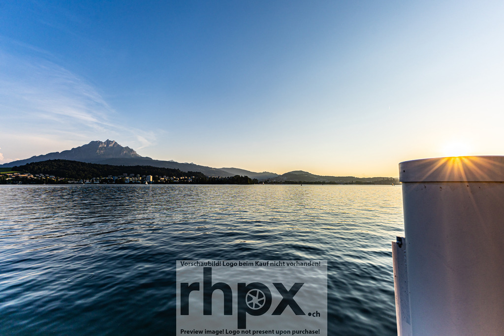 Vierwaldstättersee mit Pilatus bei Sonnenuntergang | Aufnahme des Vierwaldstättersees bei tief stehender Sonne mit Blick auf den Pilatus. Das Licht spiegelt sich auf der Wasseroberfläche und betont die klare Struktur der Landschaft. - Realisiert mit Pictrs.com