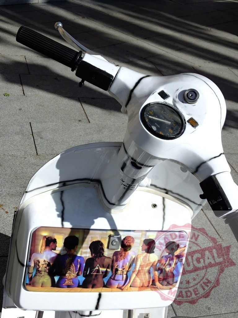 Customized scooter showing pink floyd artwork parked on sidewalk | White vintage scooter with pink floyd artwork parked on a sidewalk - Realized with Pictrs.com