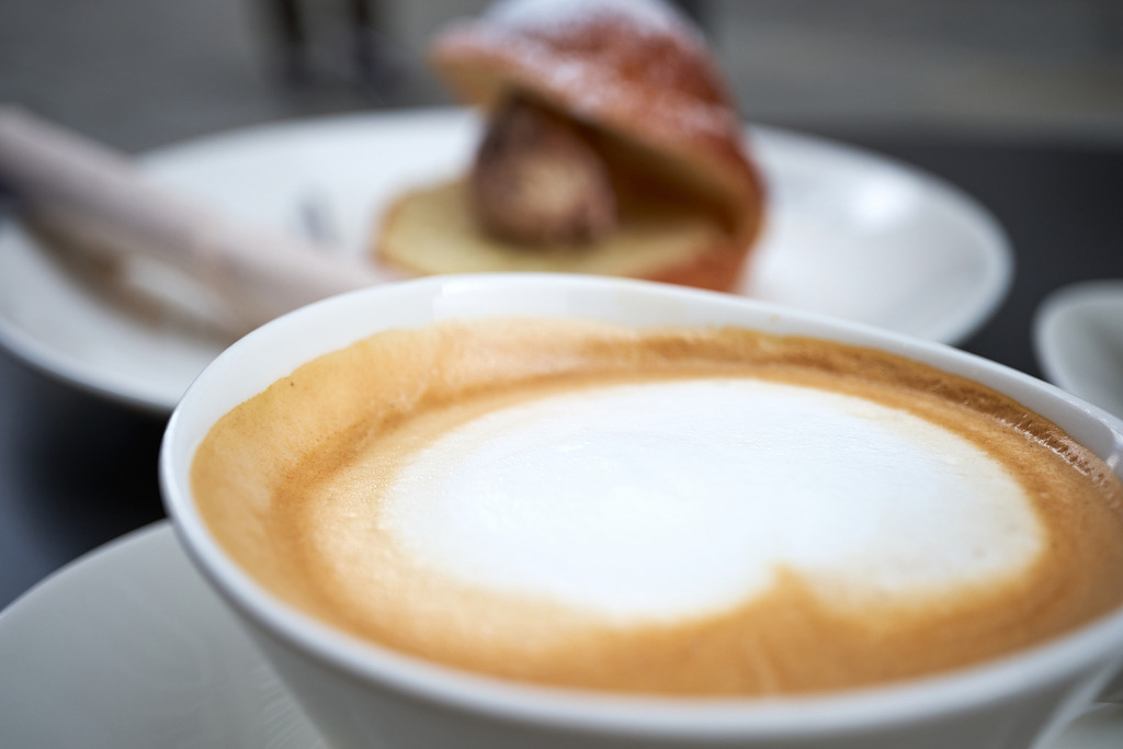 eine Brioche mit Eiskugel und einer Melange | Salzburg, Austria - April 29, 2023: eine Brioche mit Eiskugel und einer Melange steht auf dem auf dem Tisch. - Realisiert mit Pictrs.com