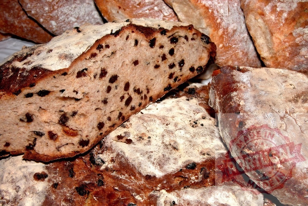 Rustic artisan raisin bread loaves with crunchy crust | Freshly baked homemade raisin bread offering a sweet and sour taste - Realized with Pictrs.com