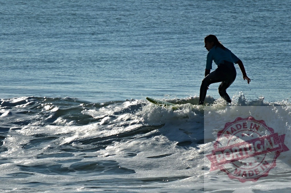 Female surfer riding wave in ocean watersports | Female surfer catching and riding an ocean wave on a surfboard - Realized with Pictrs.com