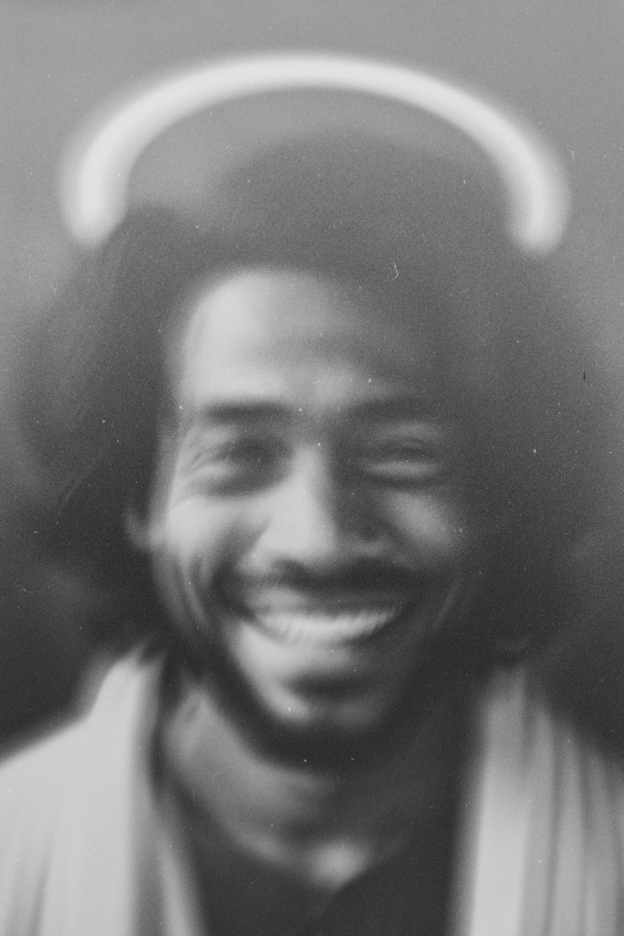 Jesus, lachend unter einer Ringleuchte | Den Sohn Gottes flüchtig und verwackelt unter der Lampe erwischt. Wenn jeder unter einer Ringleuchte stehen kann, kann dann jeder ein Heiliger sein?