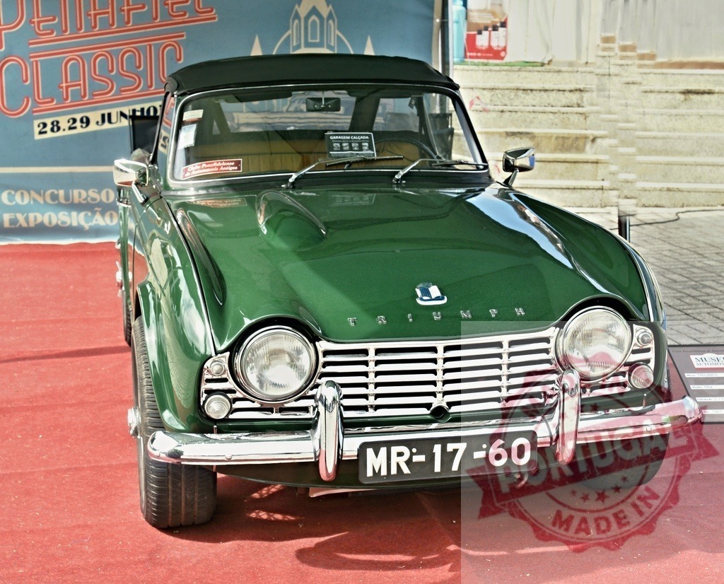 Triumph TR4 classic sports car at Penafiel Classic event | Green Triumph TR4 vintage roadster displayed on red carpet during classic car exposition - Realized with Pictrs.com