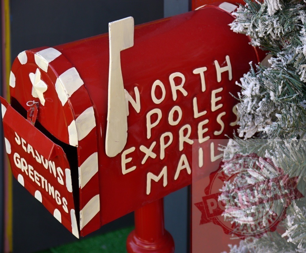 North pole express mail box with seasons greetings writing near christmas tree | North pole express mailbox with seasons greetings writing near a christmas tree with fake snow - Realisiert mit Pictrs.com