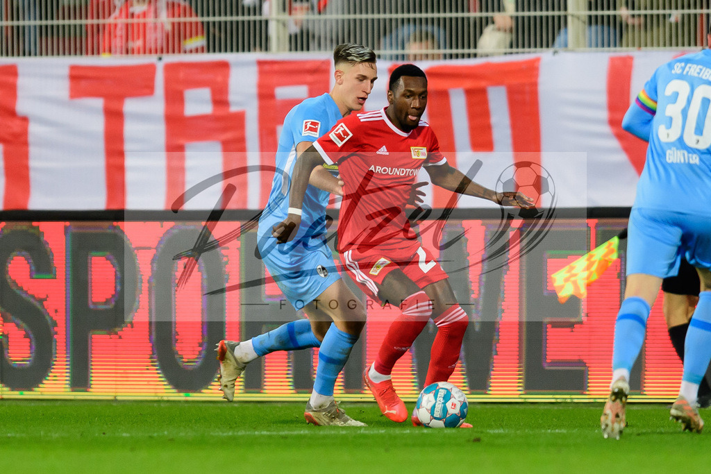 FCUFRE20211215_044 | Fussball, Herren: Nico Schlotterbeck (SC Freiburg) und Sheraldo Becker (1. FC Union Berlin) im Zweikampf bei dem Spiel der 1. Bundesliga zwischen 1. FC Union Berlin und SC Freiburg im Stadion An der Alten Foersterei am 15.12.2021 in Berlin, Deutschland.DFB / DFL REGULATIONS PROHIBIT ANY USE OF PHOTOGRAPHS AS IMAGE SEQUENCES AND/OR QUASI-VIDEO. - Realisiert mit Pictrs.com
