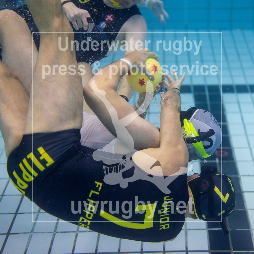 24. - 26.11.2023: Unterwasser-Rugby Champions Cup 2023  | Zwischenrunde Herren: Flipper (Dänemark) in blau gegen SDK Malmö Triton (Schweden) in weiß. Der Däne Martin Bach Kjeldgaard (blau #7) greift den Schweden Edvin  Mårtensson (weiß #10) im Mittelfeld an. - Realisiert mit Pictrs.com