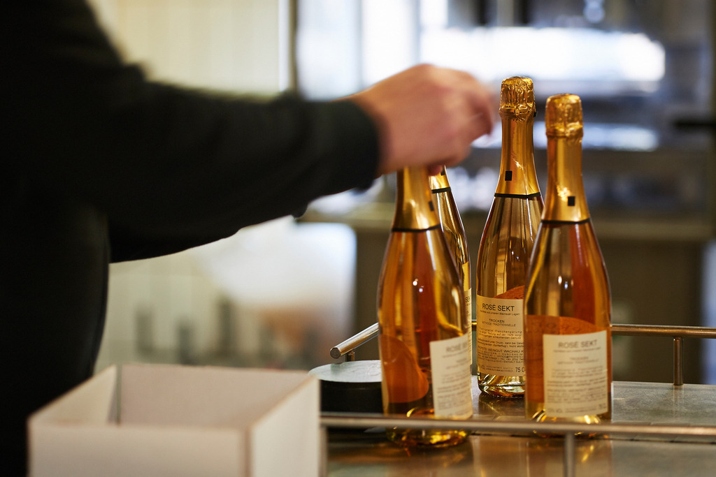 Sektkellerei Szigeti | Gols, Austria - February 19, 2018: Sektkellerei Szigeti; ein Mitarbeiter verpackt die fertigen Sektflaschen in Kartons. - Realisiert mit Pictrs.com