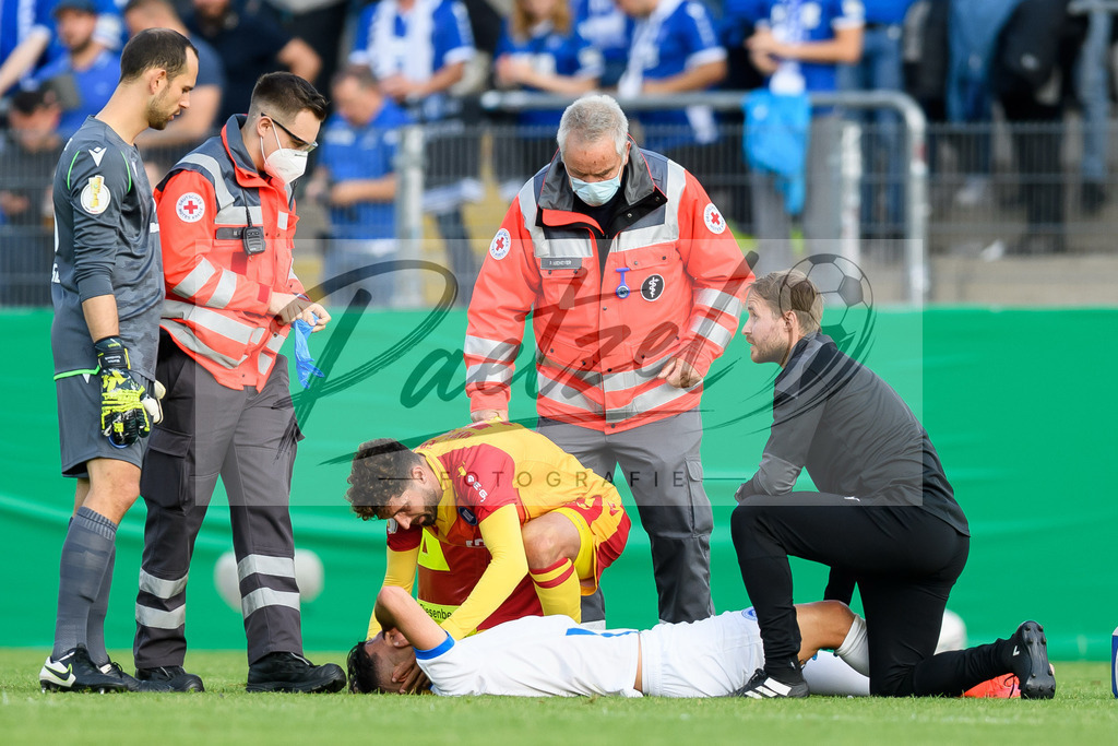LOTKSC20210809_028 | Fussball, Herren: Cinar Sansar (Sportfreunde Lotte) verletzt, wird behandelt beim Spiel der 1. Runde im DFB-Pokal zwischen SF Lotte und Karlsruher SC im Stadion am Lotter Kreuz am 09.08.2021 in Lotte, Deutschland.DFB / DFL REGULATIONS PROHIBIT ANY USE OF PHOTOGRAPHS AS IMAGE SEQUENCES AND/OR QUASI-VIDEO. - Realisiert mit Pictrs.com