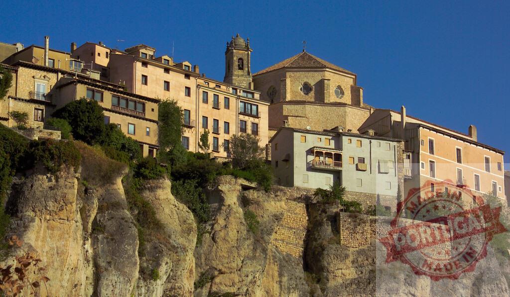 Cuenca hanging houses built on cliffside against blue sky. Cuenca - Spain | Historic buildings and cathedral forming the old town of Cuenca clinging to a rock face - Realisiert mit Pictrs.com