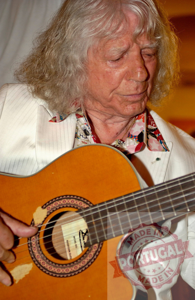 Elderly musician playing classical guitar during a concert | Senior musician playing acoustic guitar during live performance - Realized with Pictrs.com