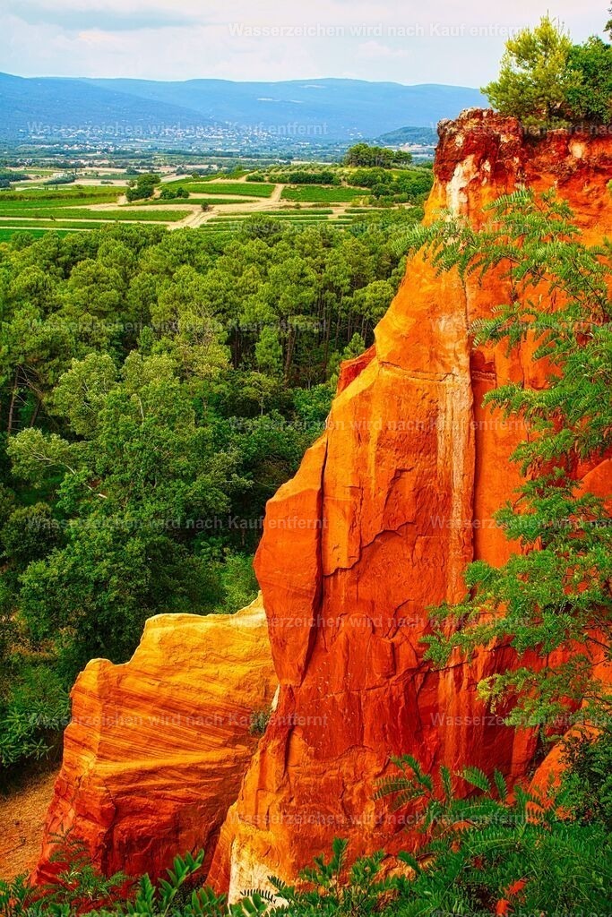 Frankreich - Roussillon - blick auf die Ockerfelsen - Sentier des Ocres in der Provence | Roussillon zählt zu den schönsten Dörfern der Provence und ist weltbekannt für seine beeindruckenden Ockerfelsen in leuchtenden Rot-, Orange- und Gelbtönen. Die einzigartige Landschaft entstand durch natürliche Ockervorkommen und Erosion und bietet mit dem Sentier des Ocres spektakuläre Fotomotive. Umgeben von der mediterranen Natur des Luberon vereint Roussillon geologische Besonderheiten, provenzalischen Charme und eine außergewöhnliche Farbenvielfalt. - Realisiert mit Pictrs.com