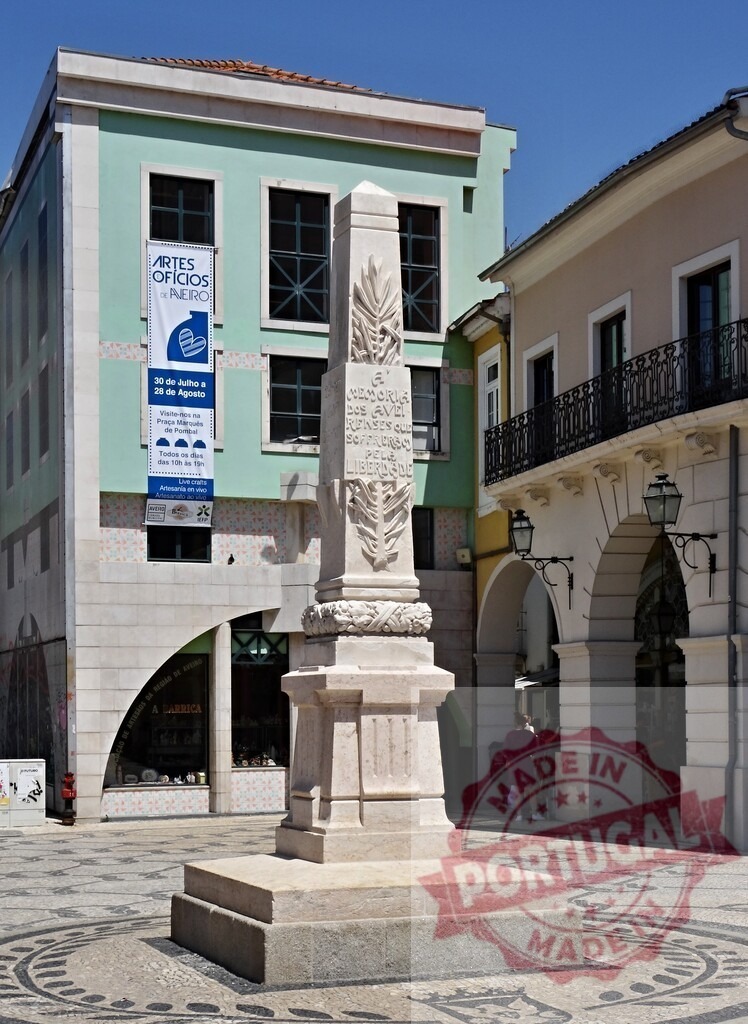 Monument to Liberty in Praça Melo Freitas, Aveiro, Portugal | Obelisk monument standing in a public square with traditional Portuguese pavement and colorful buildings - Realized with Pictrs.com